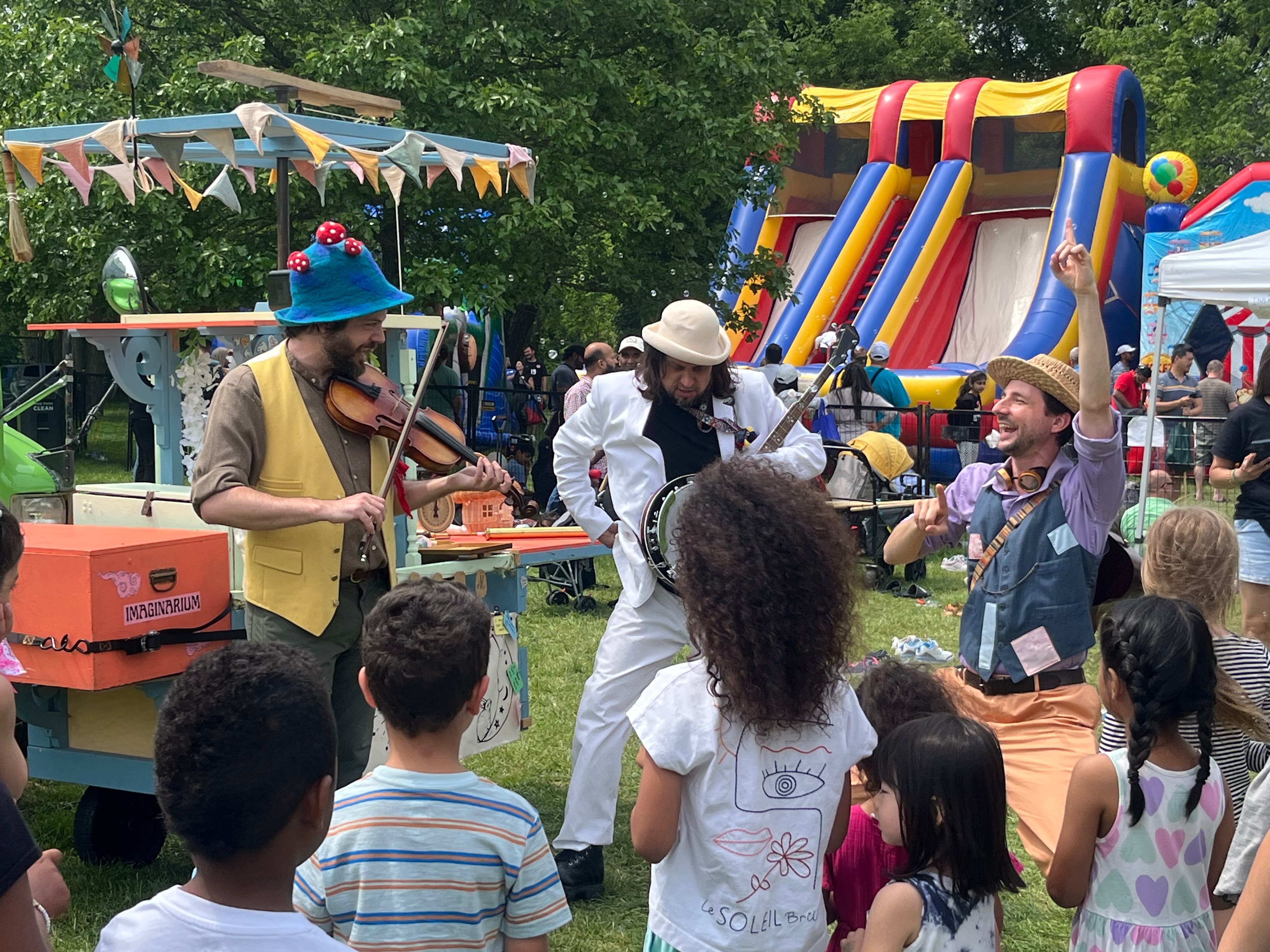 The trio plays a fiddle, banjo and cheers while the crowd interacts.